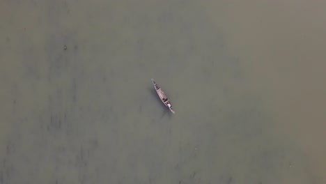 overhead aerial of stone workers collect stones in boat dholai river, bholaganj