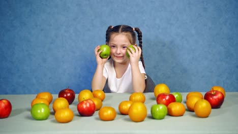beautiful girl with healthy food. happy little girl sitting on the table with fruits