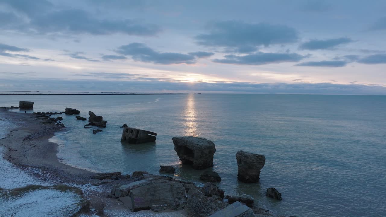 카로스타(karosta) 콘크리트 해안 요새 폐허의 아름다운 공중 전망, 잔잔한 발트해(valtic sea)의 생생한 고대비 일몰, 겨울 저녁, 앞으로 나아가는 넓은 드론 샷