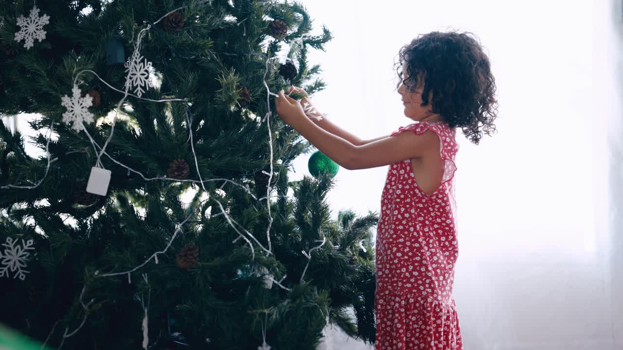 Young Girl Decorating Christmas Tree with Ornaments