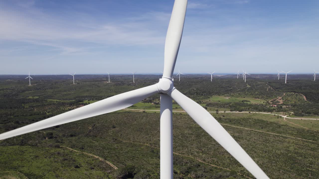 antena aérea de primer plano hacia atrás, establecer un molino eólico que produce energía verde en portugal