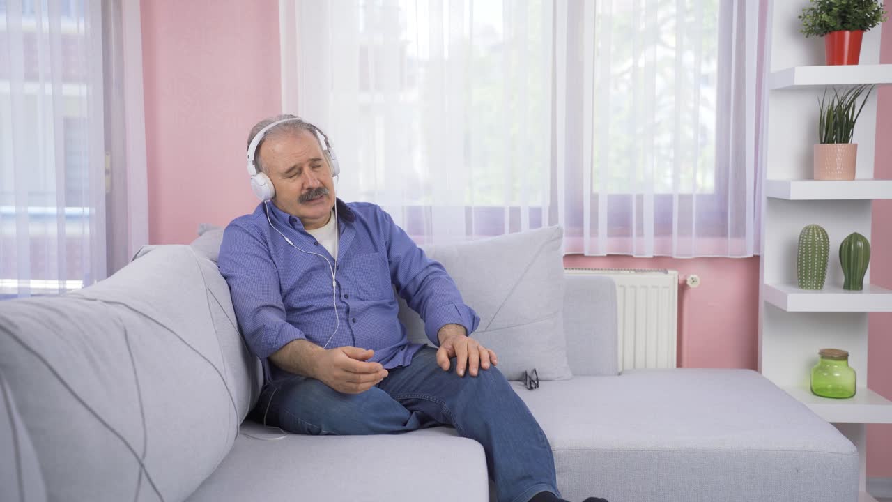 Anziano infelice che ascolta musica con le cuffie