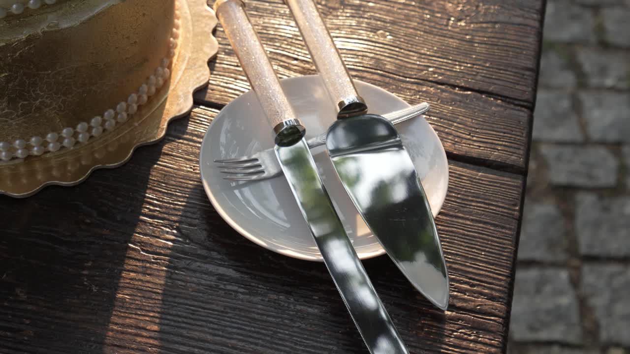 Primer plano de una tarta nupcial con cuchillo y tenedor listos para cortar