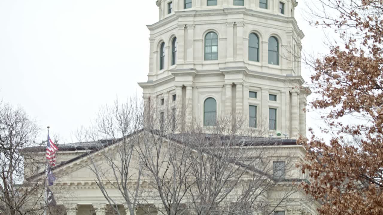 캔자스 주 토페카에서 발을 흔들고 있는 캔사스 주 의회 건물, 중간  비디오 아래로 기울어지고 있다.