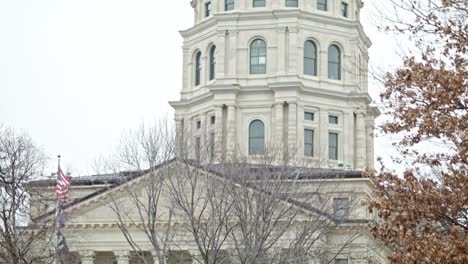 kansas state capitol building with flags waving in topeka, kansas with medium shot video tilting down