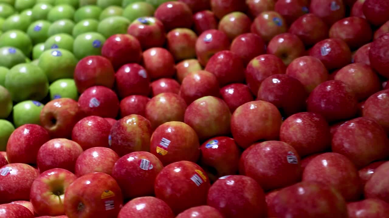 A detailed view of neatly arranged red and green apples, highlighting their vibrant colors and orderly presentation.
