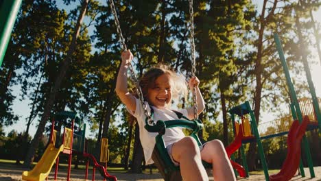 happy girl swinging on playground