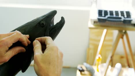 artesano trabajando en la escultura de peces 4k