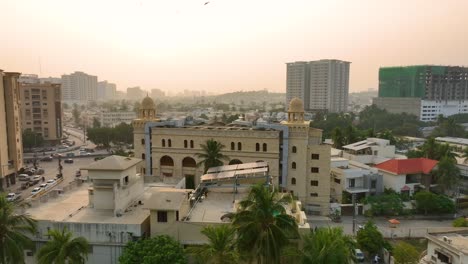 Toma-Aérea-De-Paracaídas-De-La-Vista-De-La-Ciudad-De-La-Carretera-Shaheed-e-millat-De-Karachi-Durante-La-Puesta-De-Sol-En-Pakistán