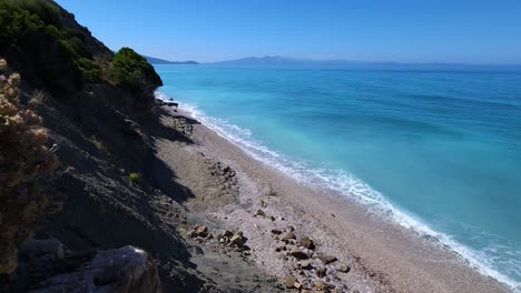 sueños de vacaciones de verano: playa blanca virgen, mar turquesa mediterráneo, y costa rocosa con olas en el paraíso mediterráneo