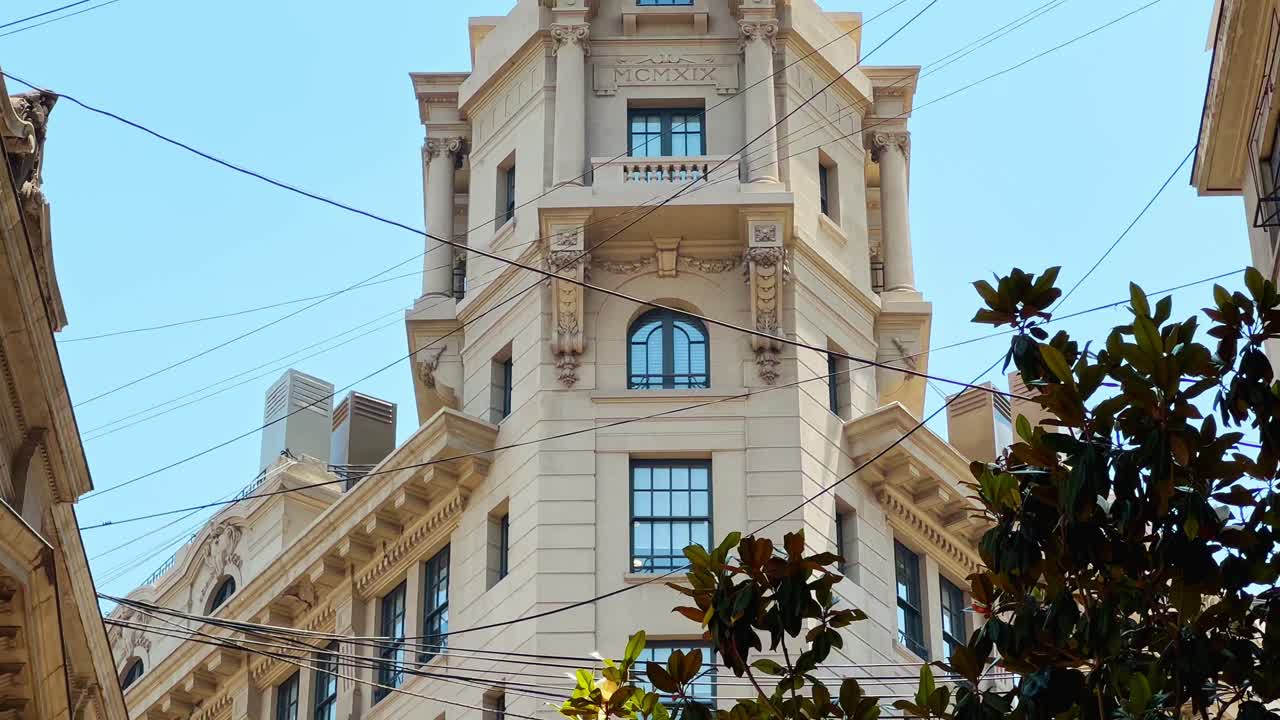 Close-up view of the top of the Arizt&iacute;a Building between strung cables on New York Street in Santiago Chile