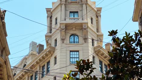 close-up view of the top of the ariztía building between strung cables on new york street in santiago chile