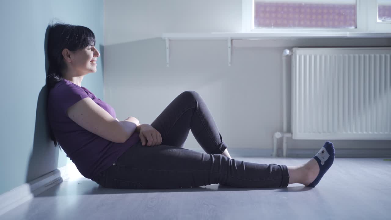 소파에 누워 있는 여자가 울고 있다.