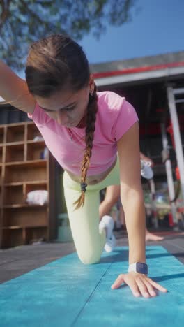 young woman performing yoga and exercise on a mat outdoors