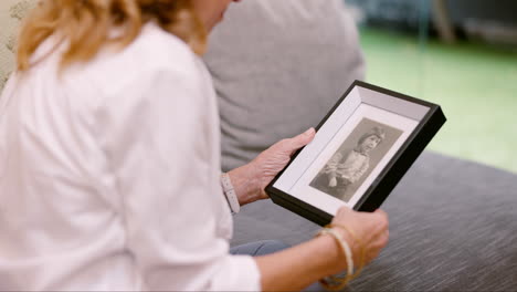 elderly woman looking at a photo of a child