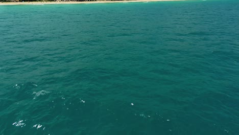 4K-Cinematic-nature-aerial-footage-of-a-drone-flying-over-the-beautiful-beach-of-Surin-in-Phuket,-Thailand-on-a-sunny-day