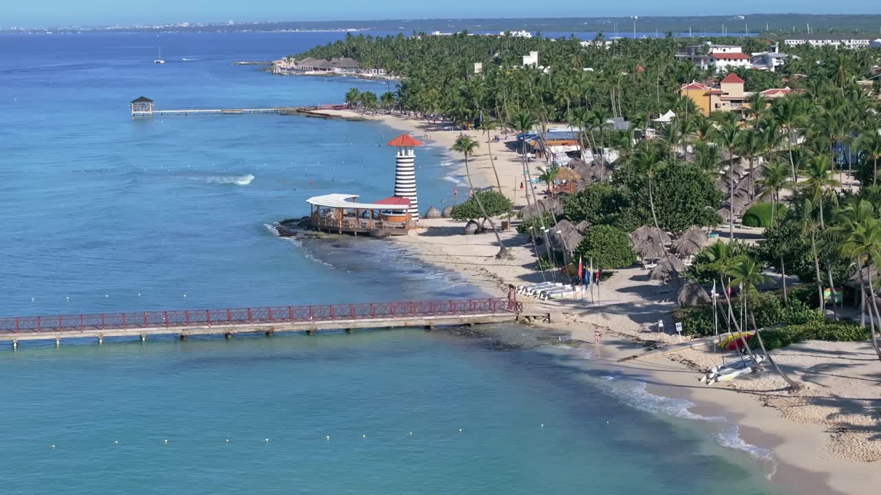 playa de dominica en bayahibe con palmeras, muelle y playa de arena