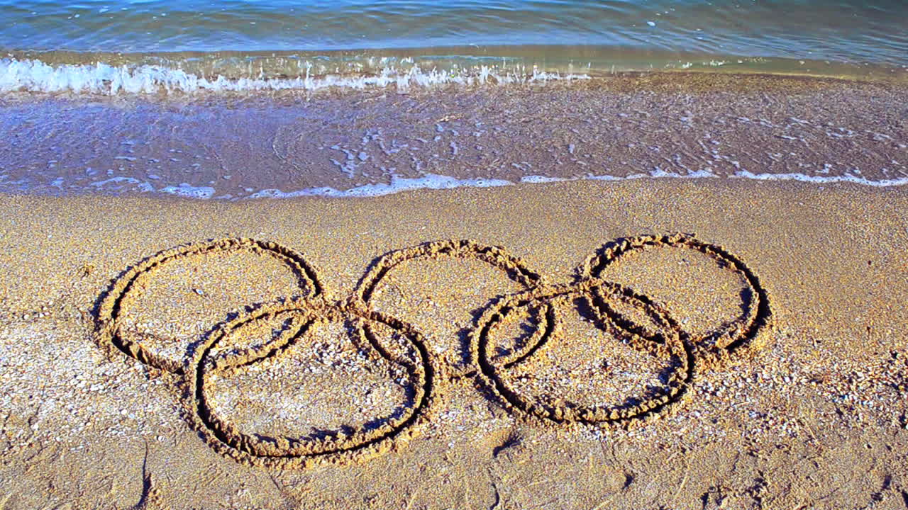 Symbol Olympic game on sand, the beach. Inscription on sand
