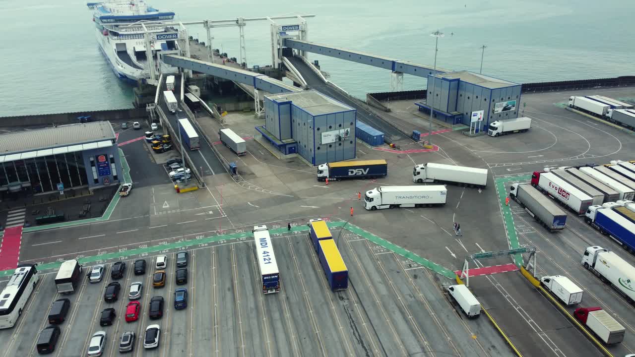 Aerial view of a busy port with ferries, trucks, and cars
