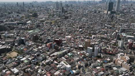 aerial scenic urban drone footage of a neighborhood, streets and buildings in the capital city of tokyo, japan on a sunny day