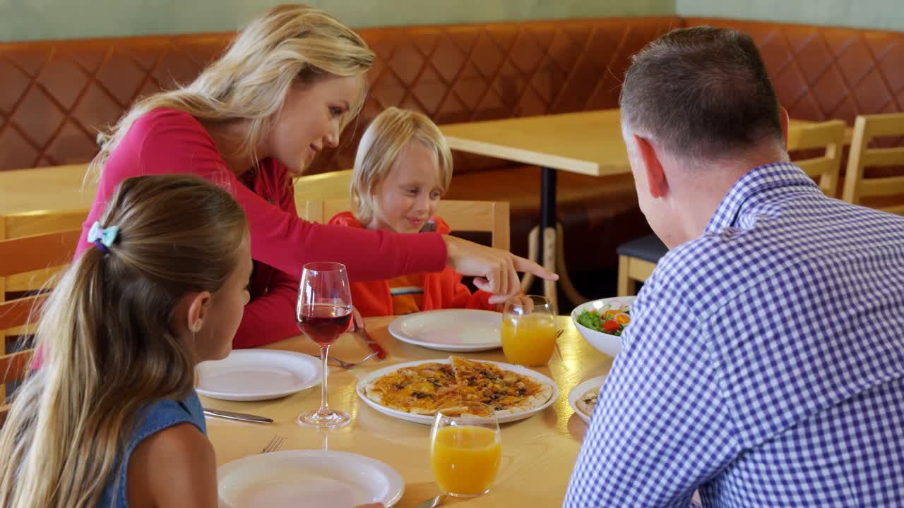 familia interactuando entre sí mientras comen 4k