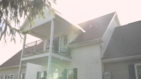 beautiful sunny reveal from behind a pine tree of a elegant white house airbnb at the strathmere resort in ottawa, canada