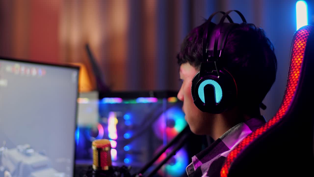 Close Up Back View Of Asian Boy Streamer Screaming Goal Celebrating Winning Game Over Network On Personal Computer.  Live Stream Video Game, Desk Illuminated By Rgb Led Strip Light