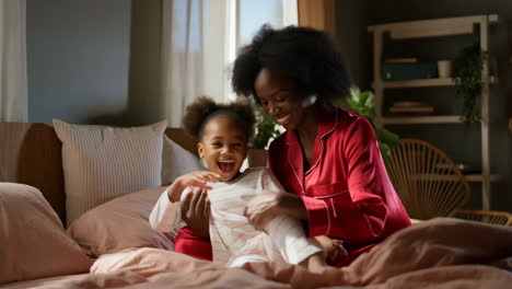 happy mother and daughter bonding in bed