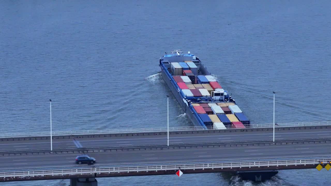 vista aérea del buque de contenedores de carga olesia navegando debajo del puente de moerdijk con el tráfico cruzando
