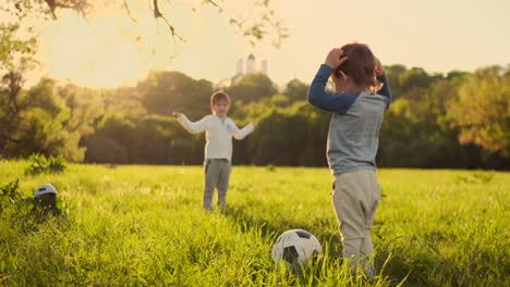 two cute little kids playing football together summertime. children playing soccer outdoor