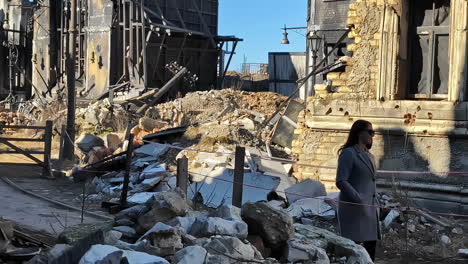 woman walking through a war-torn city - movie studio for an urban war scene