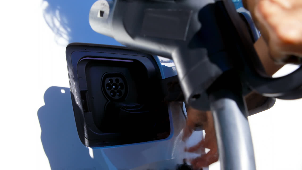 충전 스테이션에서 전기 자동차를 충전하는 여성 4k