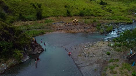 Drohnenaufnahme-Von-Menschen,-Die-In-Einen-Fluss-Springen