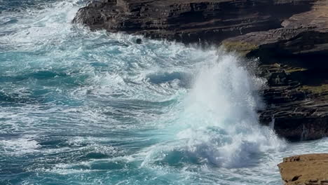 cámara lenta de olas rompiendo contra rocas en hawaii