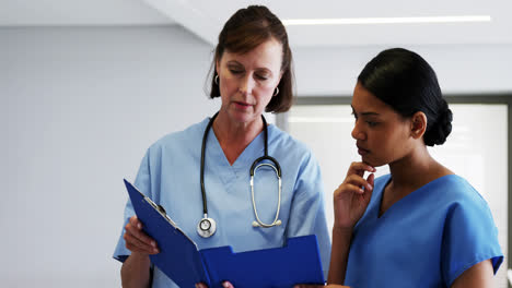 enfermera y médico discutiendo sobre el clipboard