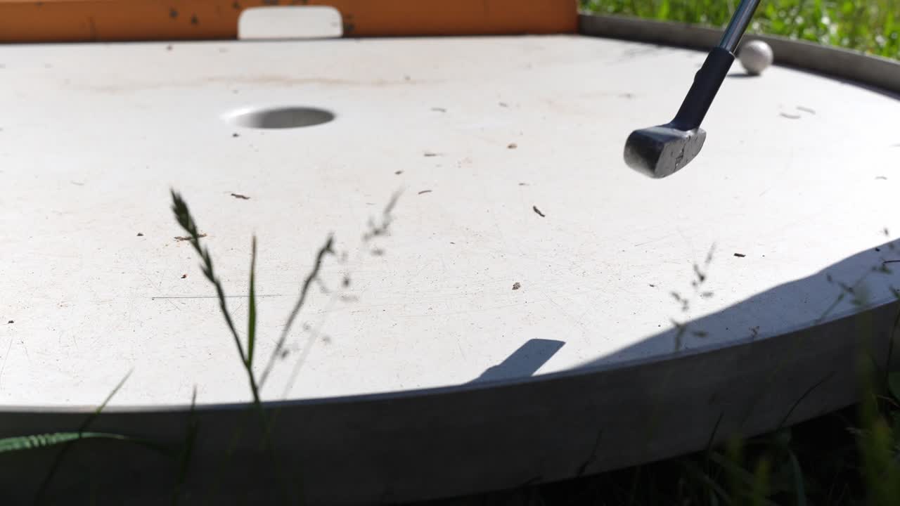 미니 골프 선수의 샷 누락, 골프공이 홀을 놓치고 정적