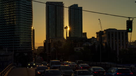 timelapse of a stunning sunset in seattle with the space needle aligned between skyscrapers, showing busy traffic and pedestrians in an urban landscape.