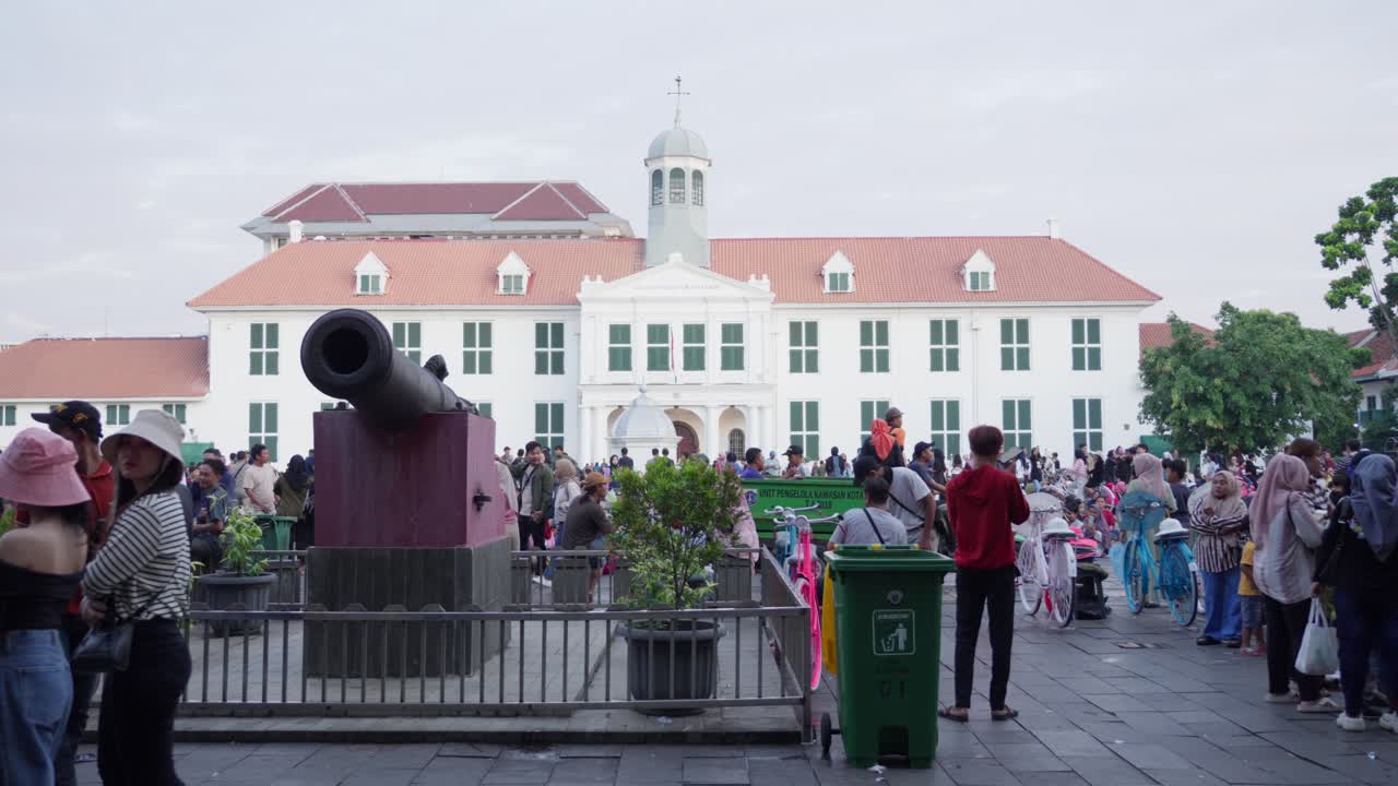Indonesian people at Taman Fatahillah, a tourist location, with Jakarta museum at backdrop