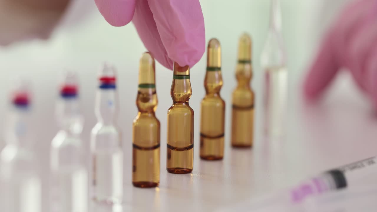 Medical Ampoules and Syringe with a Gloved Hand