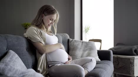 beautiful pregnant woman rubbing belly and talking with baby