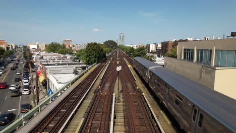 Eine-Luftaufnahme-Von-Bahngleisen-Mit-Einem-Zug,-Der-An-Einem-Sonnigen-Tag-Von-Der-Kamera-Wegfährt-1