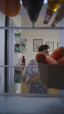 person looking inside of a refrigerator
