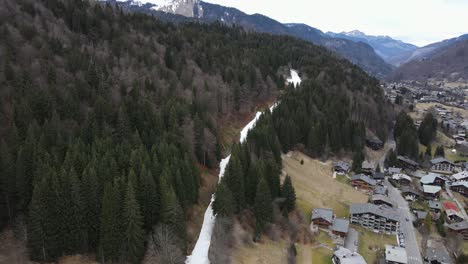 una sola franja blanca de nieve con pocas personas esquiando en ella entre el bosque en una estación de esquí francesa