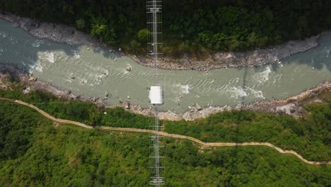 aérea de arriba hacia abajo de la selva, fluyendo y puente con bungee jumping en nepal, asia