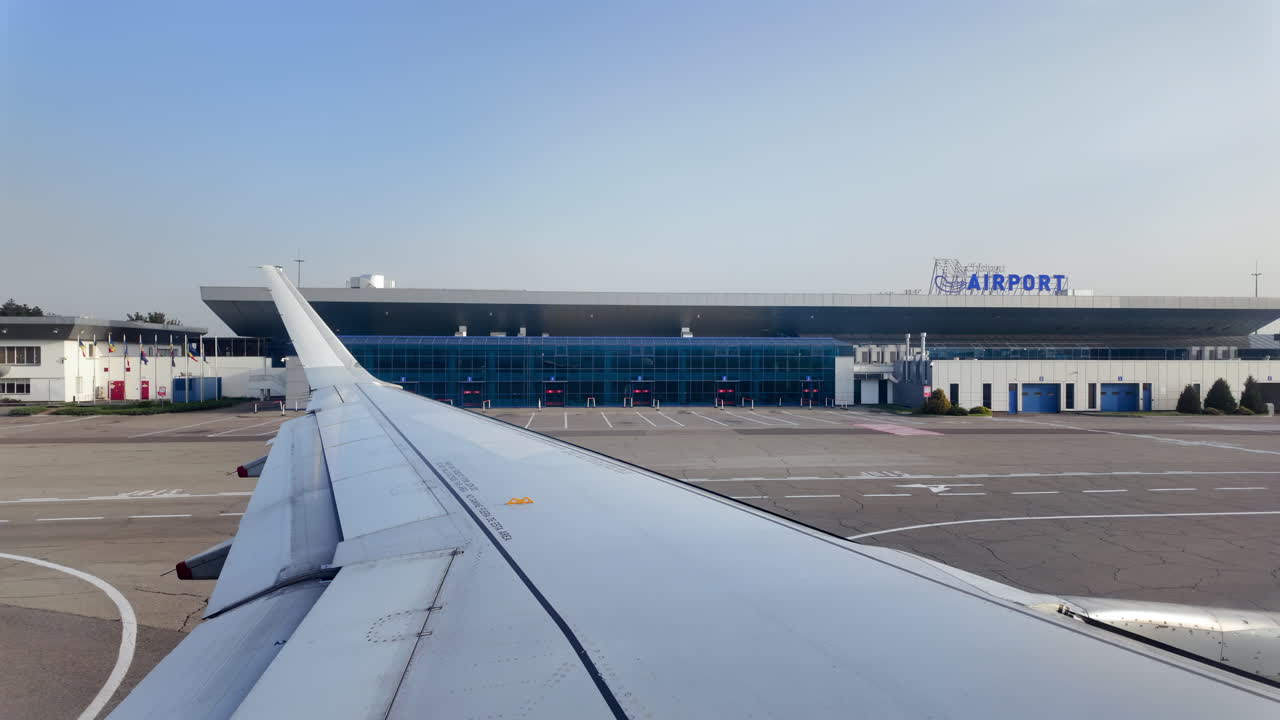 Chisinau, Moldova - July 12, 2025: View of the airplane wing from window seat moving through the Chisinau International Airport