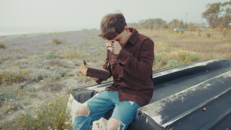man opening the bible book and starting a prayer on the shore