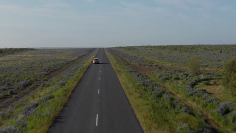 Coche-De-Vista-Aérea-Que-Viaja-En-La-Carretera-De-Circunvalación-En-Islandia.-Vista-De-Drones-Del-Impresionante-Paisaje-Islandés-Con-Conducción-De-Automóviles-Tranquila-Y-Pacífica