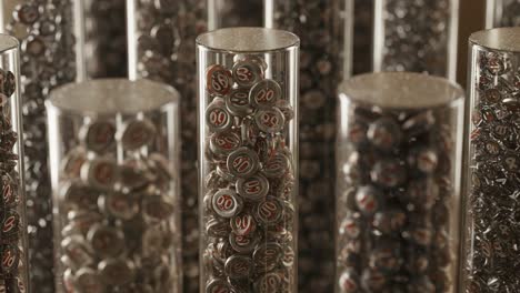 a close-up view of colorful metallic tokens displayed in crystal containers, showcasing their intricate details and unique designs for collectors and enthusiasts