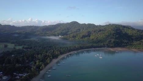 antena de un tranquilo pueblo de pescadores en una mañana soleada en filipinas - tiro de seguimiento hacia atrás