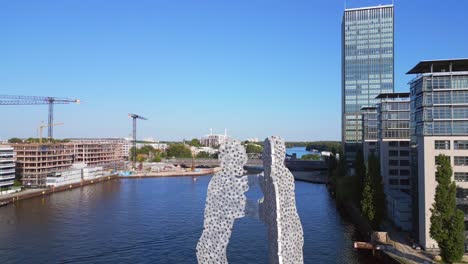 Marvelous-aerial-top-view-flight-Molecule-Man-on-border-river-Spree,-east-Berlin-Germany-evening-summer-23